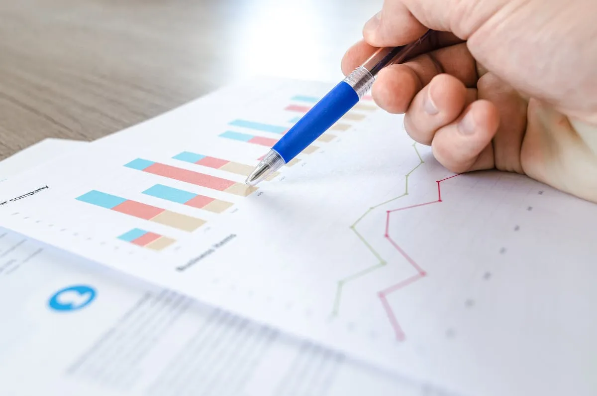Empresário verificando resultados em planilha com expressão de satisfação