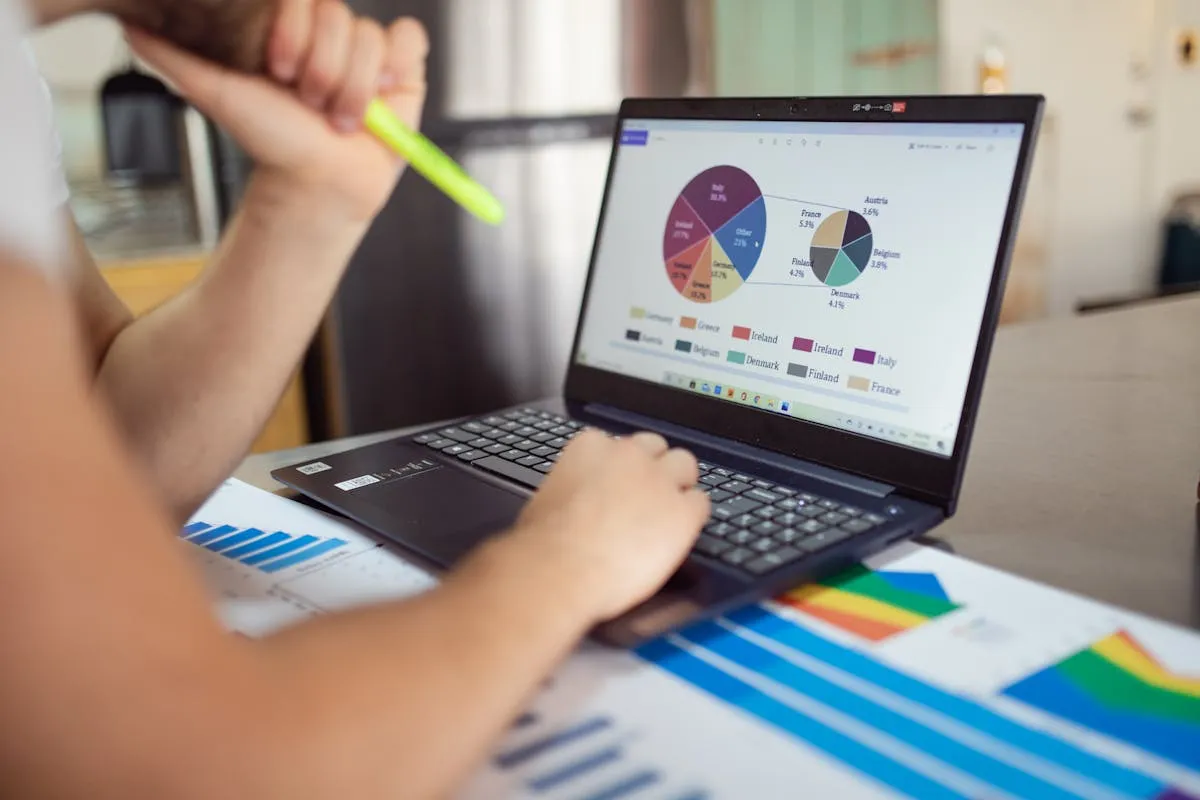 Empresario analisando graficos e metricas em notebook em mesa de escritorio