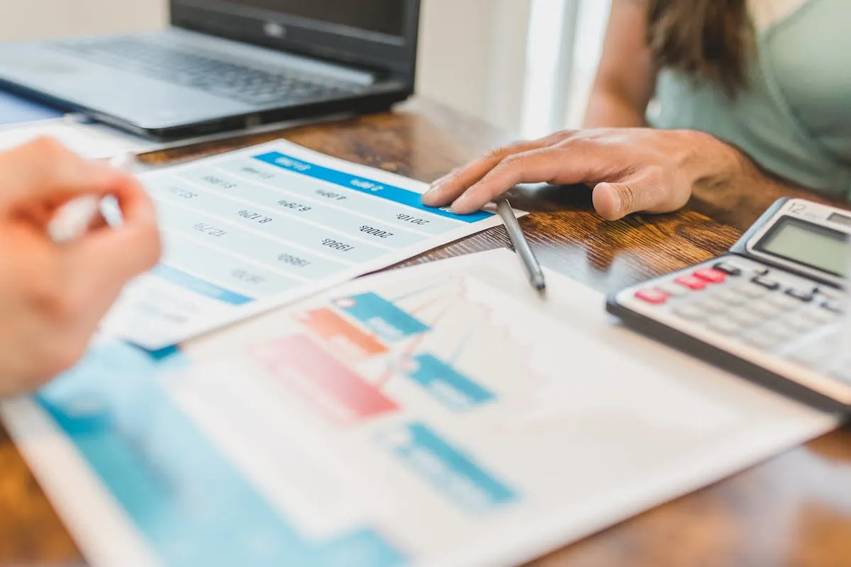 Dono de negócio analisando planilha no computador, avaliando resultados do mês