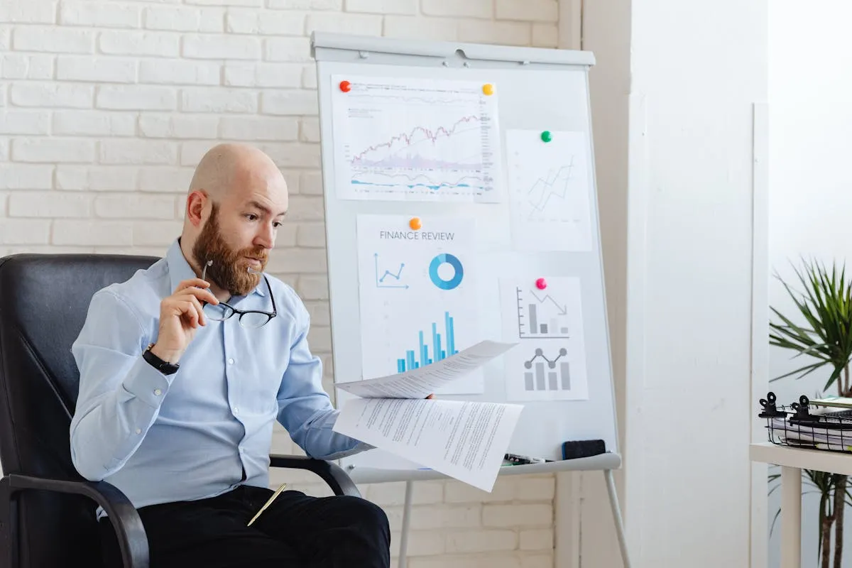 Empresário analisando gráfico de resultado mensal em notebook com expressão satisfeita