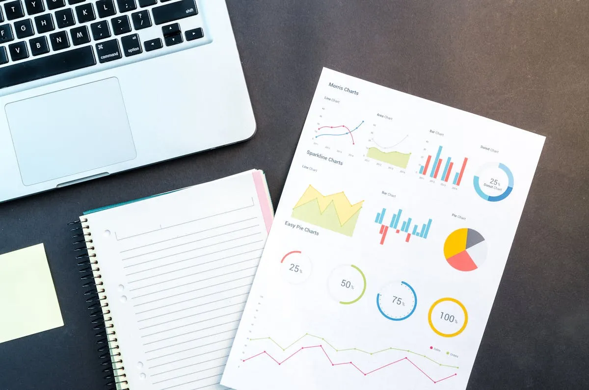 Empresário analisando resultados no notebook com caderno de anotações ao lado
