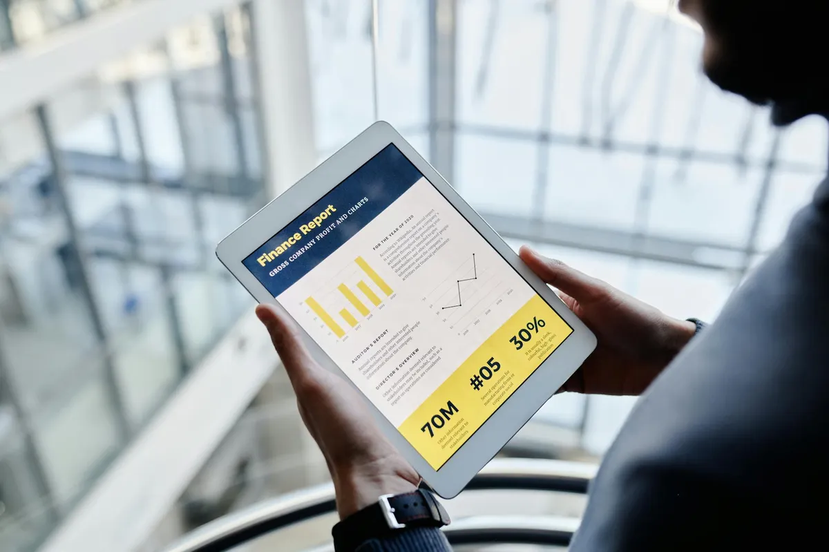 Empresário olhando para tablet com relatório aberto no escritório