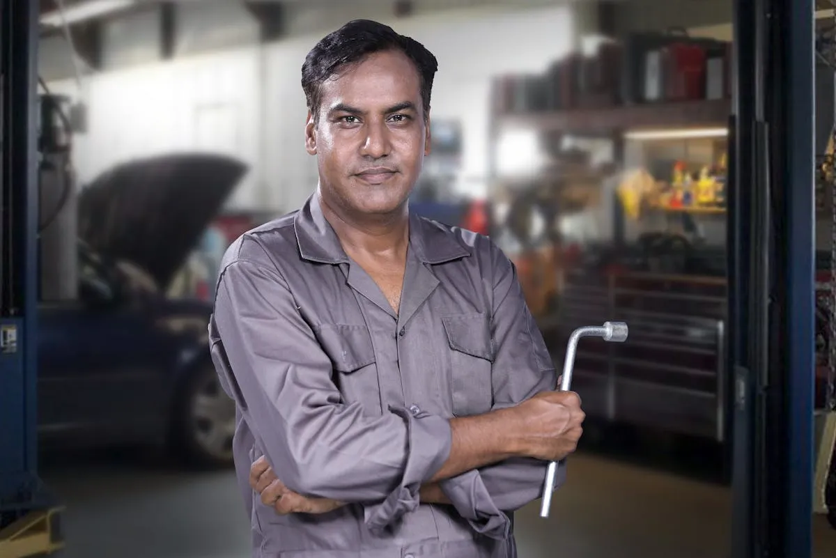Mecânico em frente a laptop usando inteligência artificial para gestão de oficina automobilística