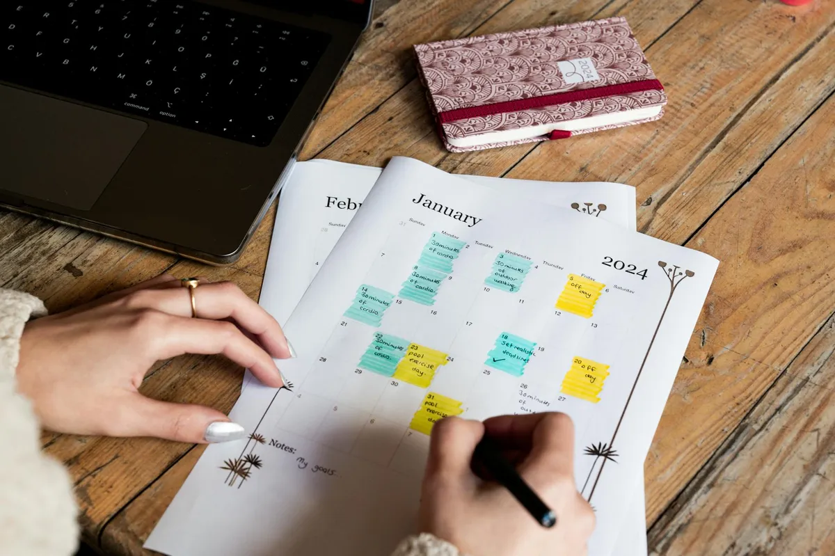 Empresário olhando para calendário e laptop, planejando cronograma