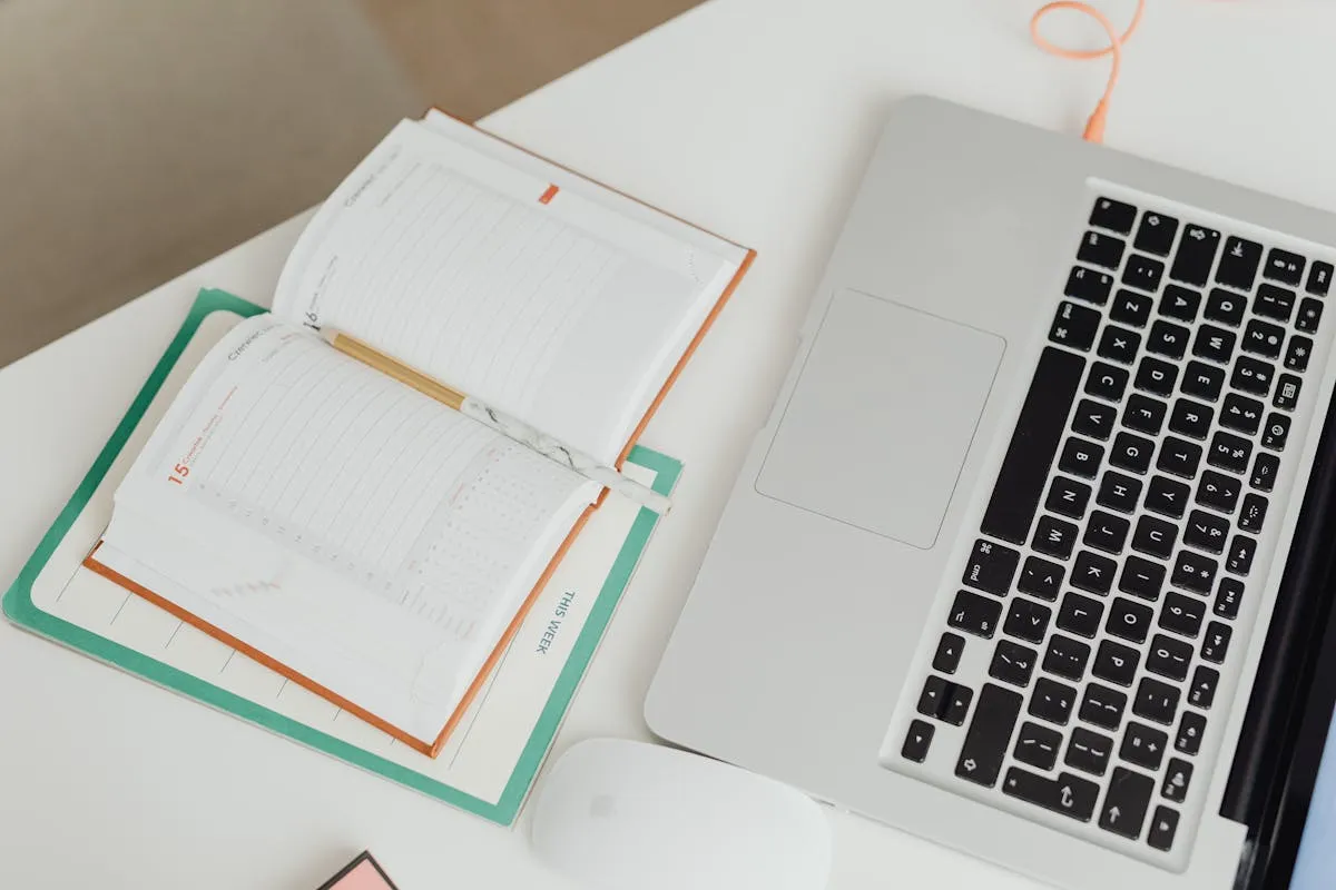 Calendário de planejamento sobre mesa com notebook e caneta ao lado