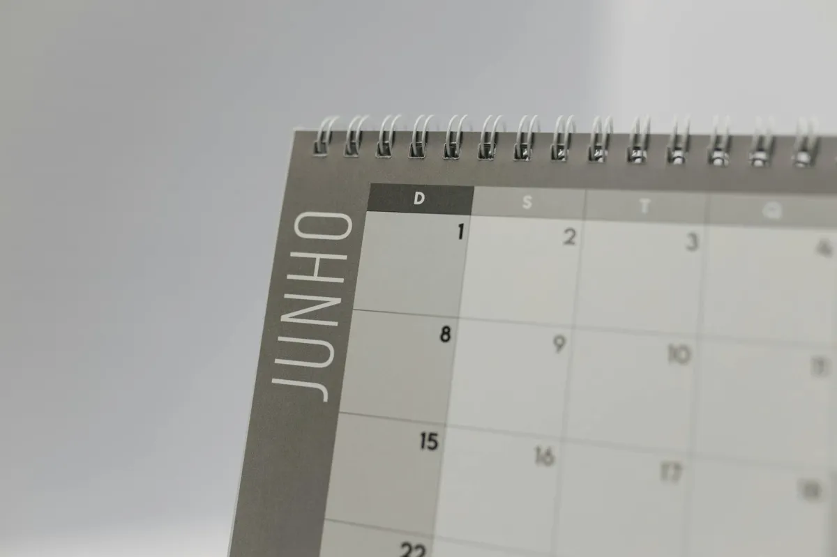 Calendário sobre mesa com post-it e caneta indicando prazo de projeto