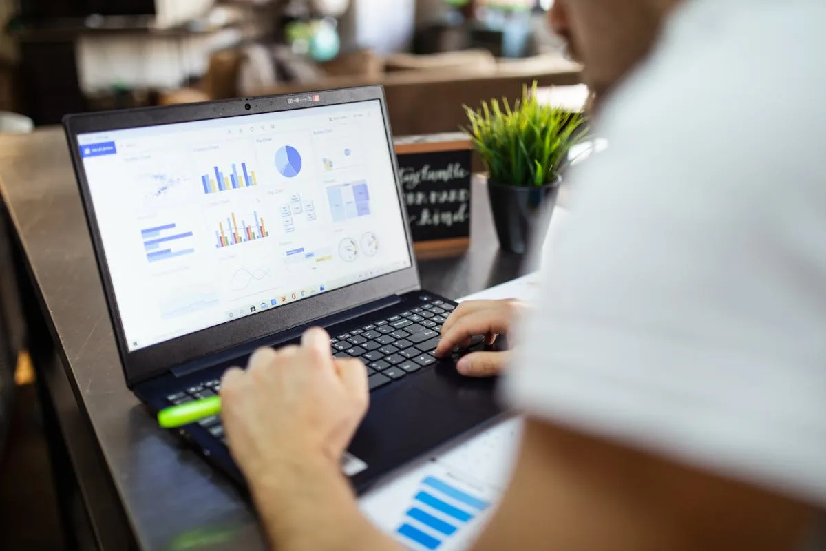 Dono de negócio analisando planilha no computador em escritório organizado