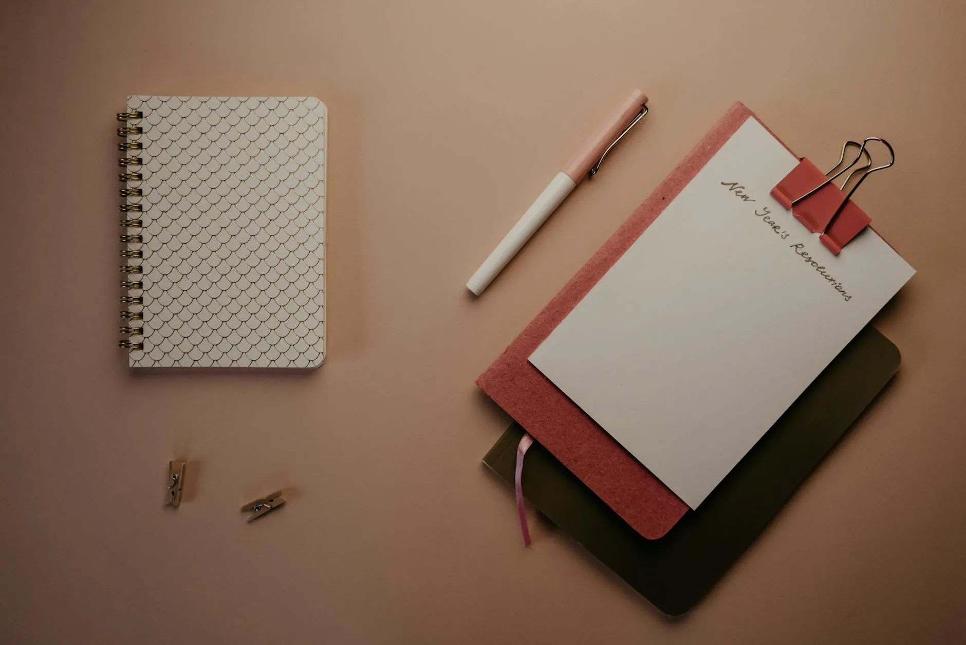 Bloco de notas com metas escritas à mão sobre mesa de trabalho