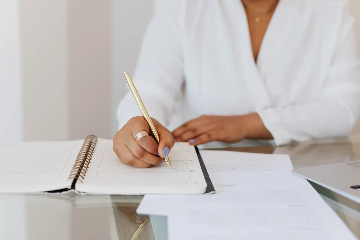 Dono de negócio com bloco de notas fazendo anotações antes de abrir o computador