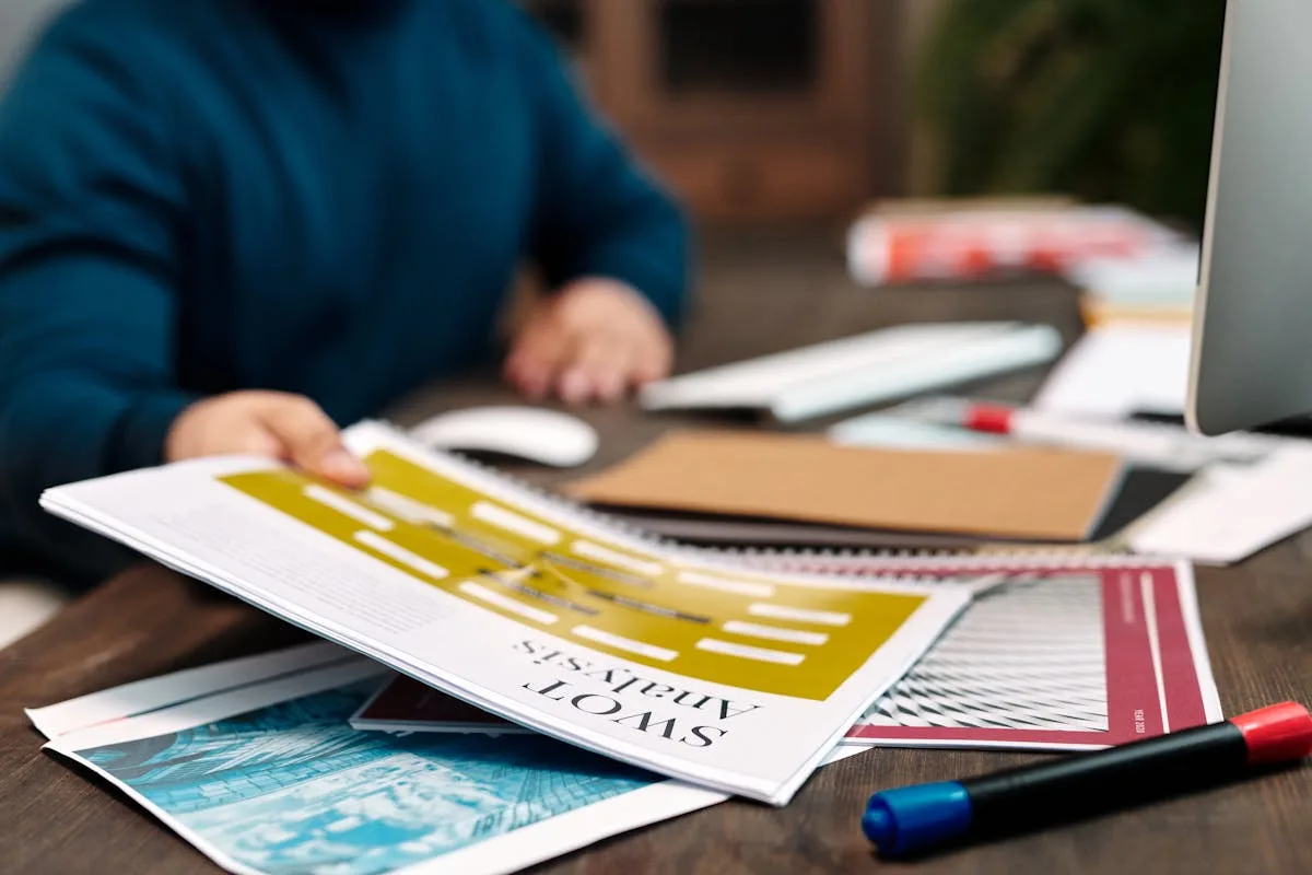 Empresário planejando estratégia em papel antes de iniciar projeto no computador