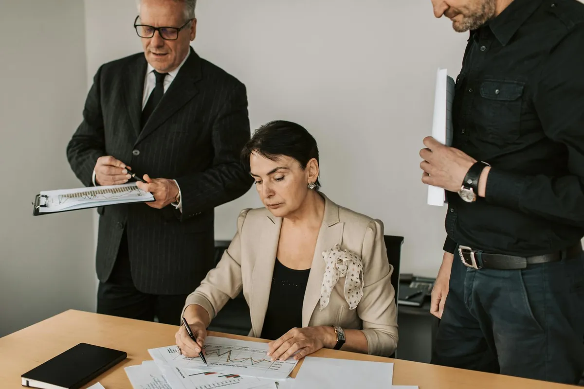 Dono de negócio e equipe revisando resultados financeiros do mês juntos