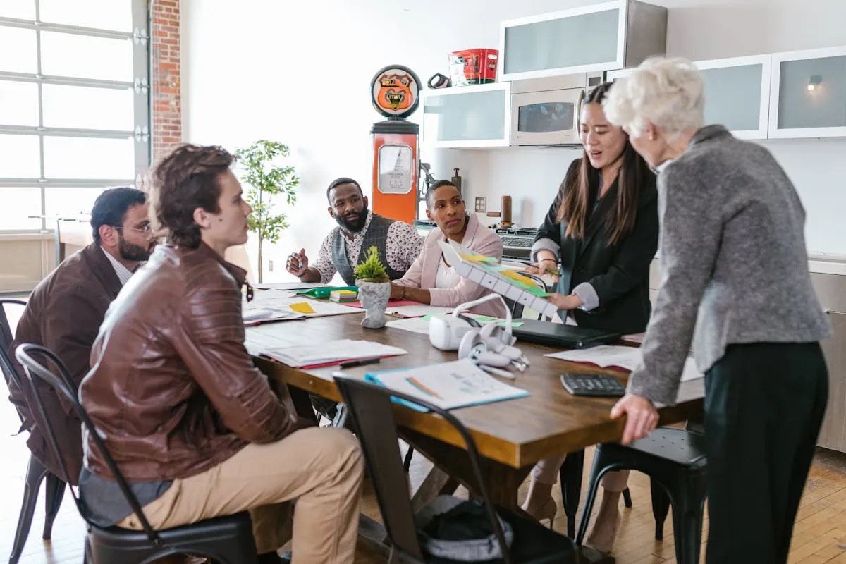Empresário e equipe colaborando em torno de mesa de trabalho