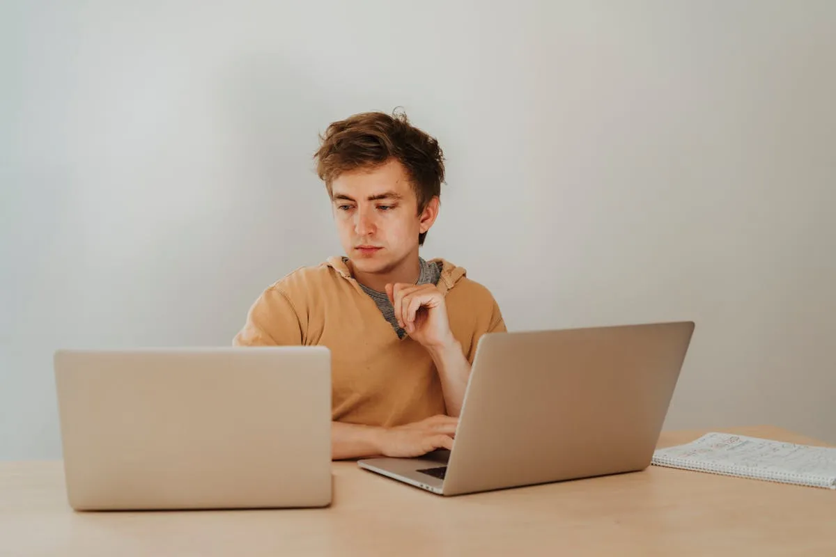 Três laptops abertos lado a lado mostrando interfaces de ferramentas digitais diferentes