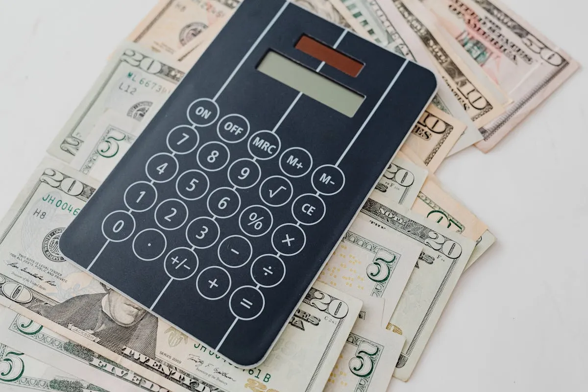 Empresário calculando custos com calculadora e planilha na mesa