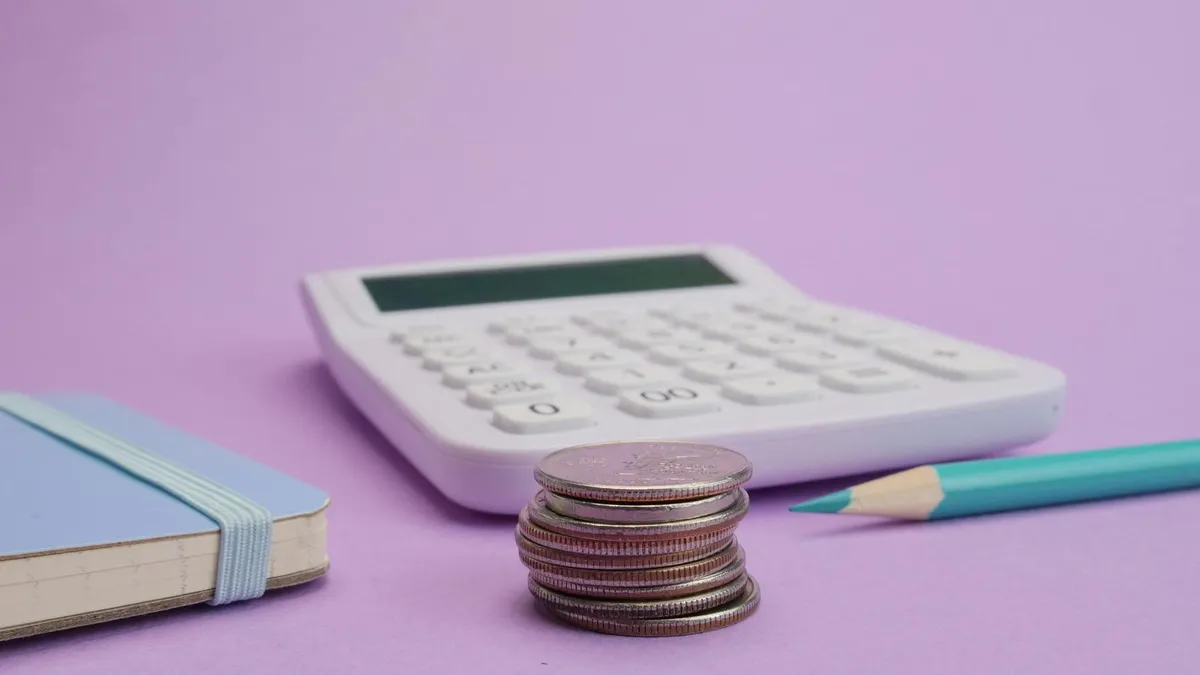 Calculadora sobre mesa com papéis de contas, representando controle de custos no negócio