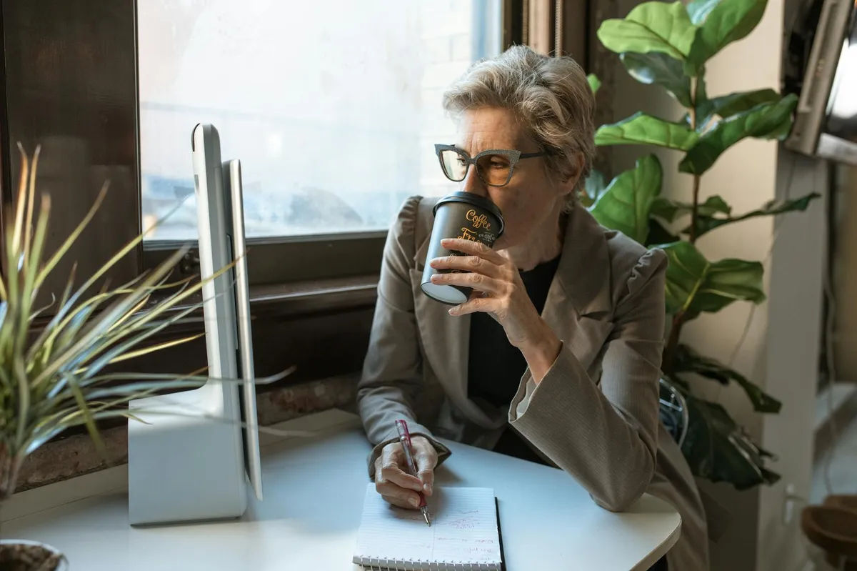 Empresário mais velho usando computador simples para anotar informações do negócio