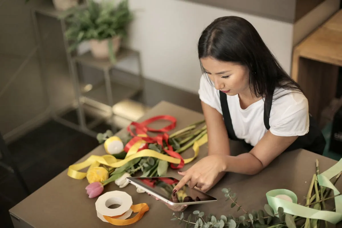 Dono de pequena empresa sentado à mesa com tablet nas mãos, aprendendo a usar tecnologia no negócio